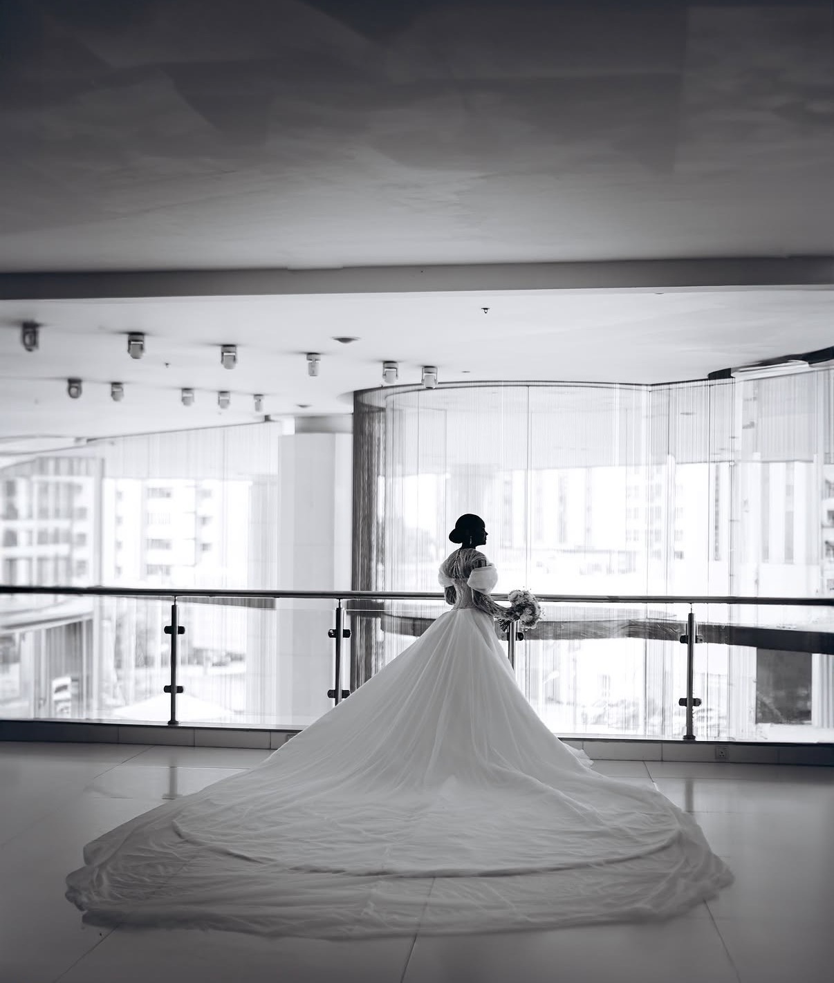 Bride in flowing gown overlooking the city
